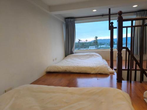 a bedroom with two beds and a balcony with a view at 馨舍民宿 in Xinshe
