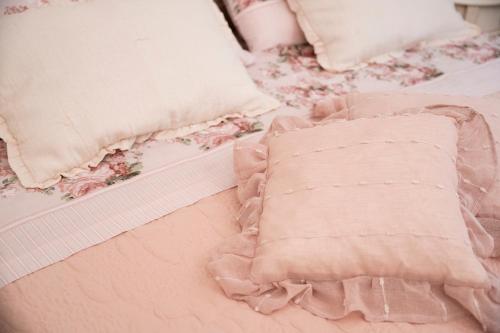 a pink bed with pillows and a pink comforter at Lajatico Rentals -Grotticella House, SPA Apartment in Peccioli in Peccioli