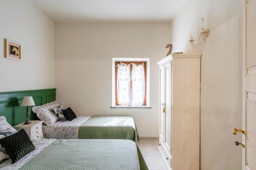 a bedroom with two beds and a window at Lajatico Rentals -Grotticella House, SPA Apartment in Peccioli in Peccioli