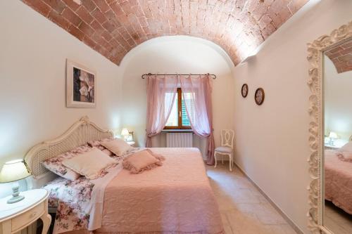a bedroom with a bed and a brick wall at Lajatico Rentals -Grotticella House, SPA Apartment in Peccioli in Peccioli