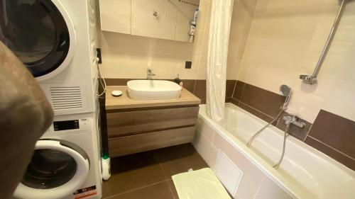 a bathroom with a sink and a washing machine at Strelitzyahouse in Brussels