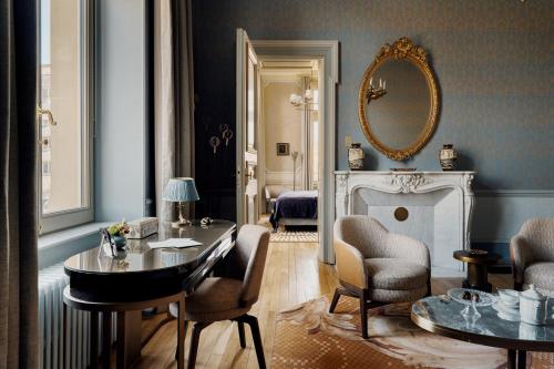 a living room with a table and chairs and a mirror at Villa Pétrusse in Luxembourg