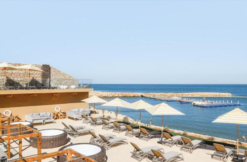a beach with chairs and umbrellas and the ocean at Bavaro Beach Dakhla in Dakhla