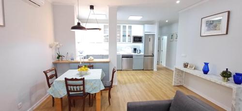 a kitchen and living room with a table and chairs at Lxroller Seomara Apartment 3 Bdr in Amadora