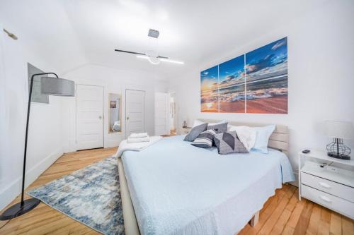 a white bedroom with a large bed and a blue rug at Kenmore Akron 3 bedroom 1 bath in Akron