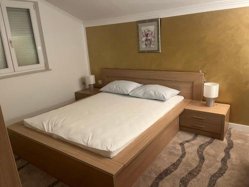 ラブにあるCaptain's Apartmentのベッドルーム1室(白いシーツとランプ2つ付)