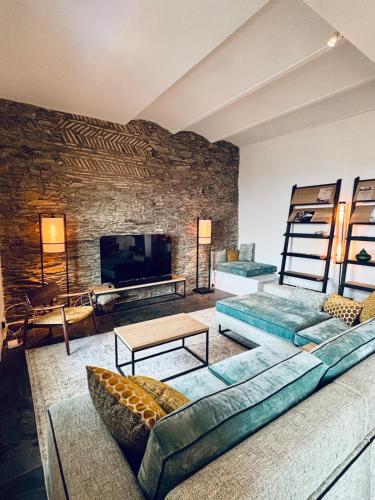 a living room with couches and a stone wall at Casa Amici - Luxe in Cadaqués in Cadaqués