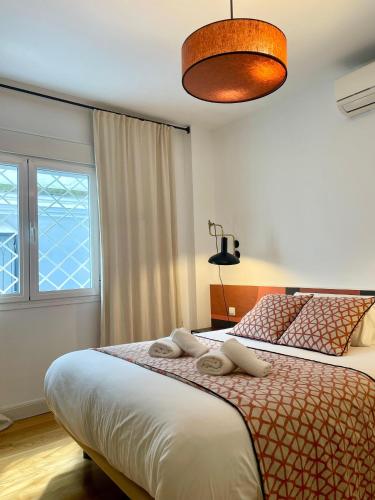 a bedroom with two beds and a large window at The Zentral Suites & Apartments in Seville