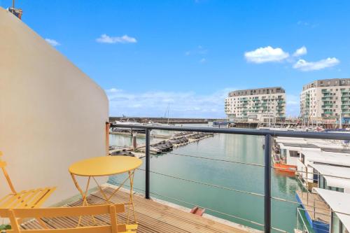 a balcony with a table and a view of the water at On the Water 6 A One-of-a-Kind Stay Free Parking By My Getaways in Brighton & Hove
