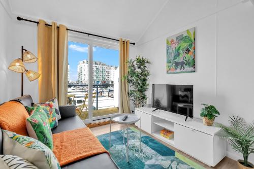 a living room with a couch and a tv at On the Water 6 A One-of-a-Kind Stay Free Parking By My Getaways in Brighton & Hove