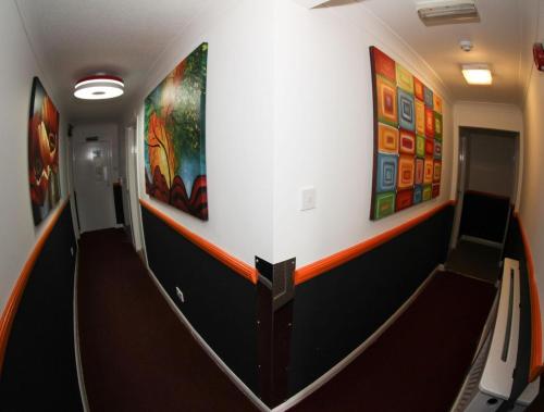 a hallway in a train with paintings on the wall at Heathrow Inn Hotel in Hillingdon