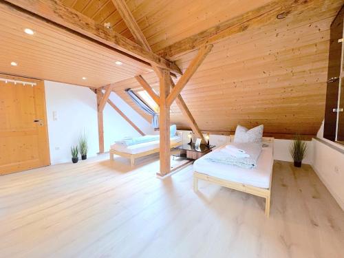 a large room with two beds and a wooden ceiling at III Apartment 6 Personen - Monteurzimmer - Ferienwohnung - Dingolfing in Dingolfing