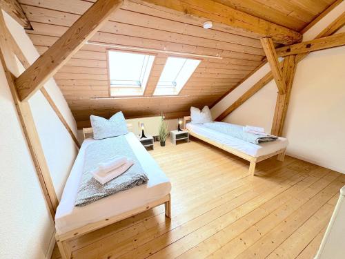 two beds in a attic room with wooden ceilings at III Apartment 6 Personen - Monteurzimmer - Ferienwohnung - Dingolfing in Dingolfing