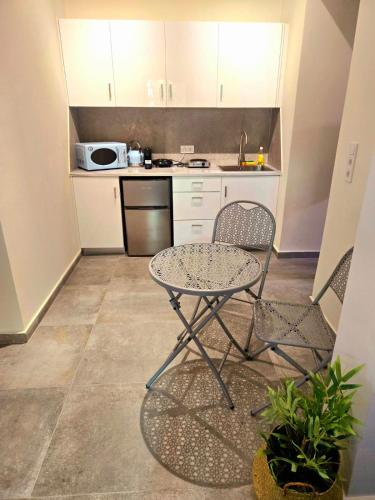 a kitchen with a table and two chairs and a sink at Pirgos Cozy Apartment for 4 by MPS in Pýrgos