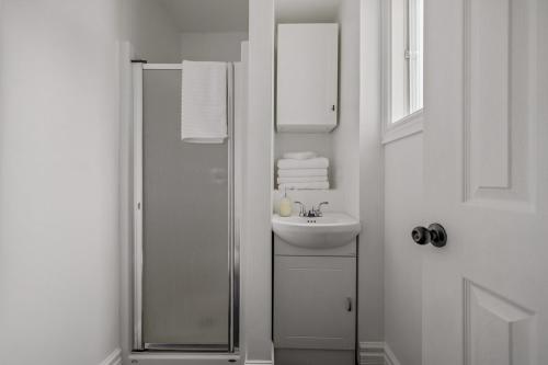 a white bathroom with a shower and a sink at Le Petit Cozy, 1 CH, Bureau, Enfant-Jésus in Quebec City