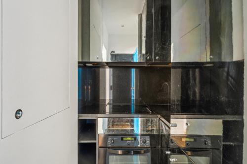 Il comprend une cuisine équipée d'une cuisinière et d'un miroir. dans l'établissement Superb Apartment 1BR 2P - Cœur du Marais, à Paris