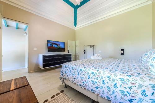 a bedroom with a bed and a flat screen tv at Casa Condominio Piccola Paraty in Paraty
