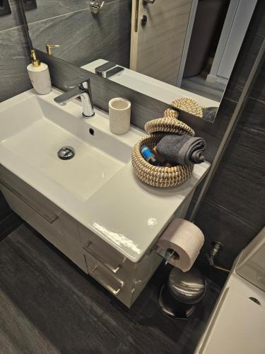 a bathroom with a white sink and a mirror at TRISAP Luxury Suites T Suite in Thessaloniki