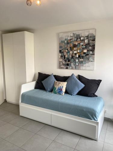 - une chambre dotée d'un lit avec des draps bleus et un tableau dans l'établissement Ma place au sud Nice 604, à Nice