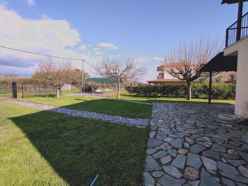 a stone walkway in a yard next to a house at Kerasies Home in Karianí