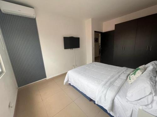 a bedroom with a white bed and a flat screen tv at Blue Dream in San Francisco in Panama City