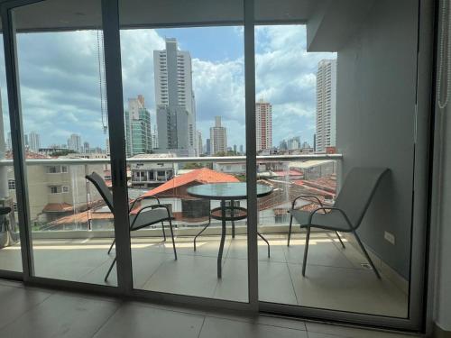 a balcony with a table and chairs and a view of a city at Blue Dream in San Francisco in Panama City