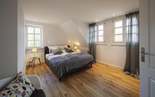 a bedroom with a bed and two windows at Ferienhaus Am Untergut in der Klingelstraße in Lüchow