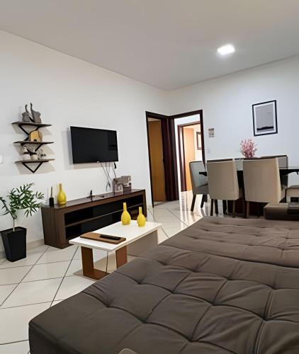 a living room with a large bed and a television at Residencial Vicente Vaz in Patos de Minas