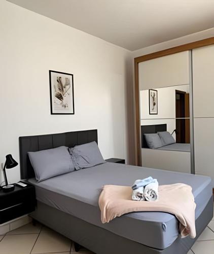 a bedroom with a bed and a mirror at Residencial Vicente Vaz in Patos de Minas