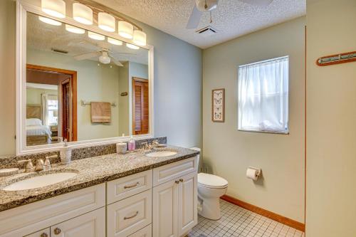 a bathroom with two sinks and a mirror and a toilet at Private Outdoor Oasis Luxe Palm Coast Retreat in Palm Coast