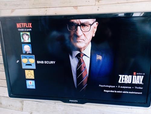 a movie poster of a man in a suit on a tv at Magnifique bâtisse champenoise, jardins, billards, parking in Écury-sur-Coole