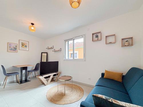 un salon avec un canapé bleu et une table dans l'établissement Confort & Élégance - Wifi, 2 pers, à Nice