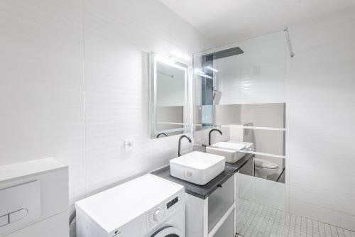 une salle de bain blanche avec deux lavabos et un miroir dans l'établissement M70 Marquer Studio proche de la gare, à Annemasse