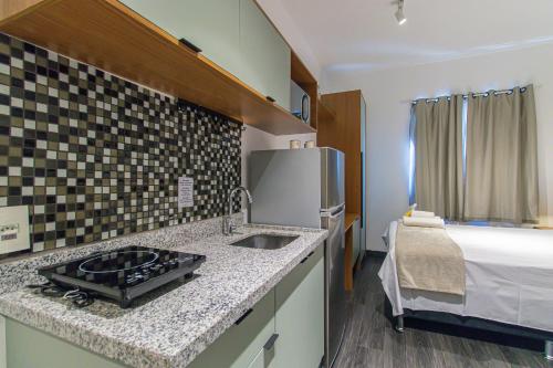 a kitchen with a stove and a sink and a bed at Aconchegante Studio em Sao Paulo - SP-A713 in São Caetano do Sul