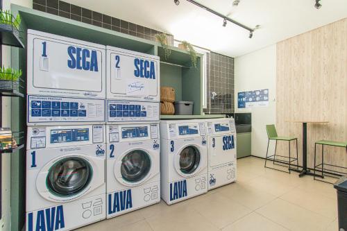 a laundry room with four washing machines and a counter at Aconchegante Studio em Sao Paulo - SP-A713 in São Caetano do Sul