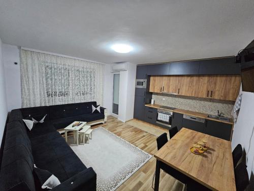 a living room with a black couch and a table at A&M apartments in Lipjan