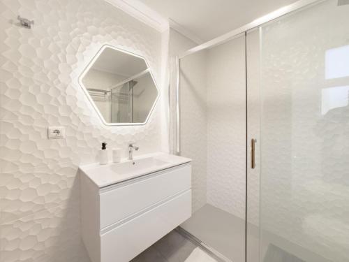 a white bathroom with a sink and a mirror at BoLina Ocean View in Caniço
