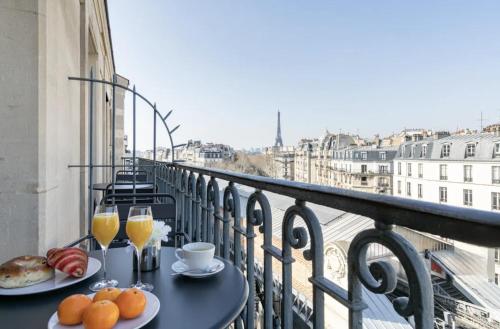 a balcony with a table with food and glasses of orange juice at Sublim by Sweett in Paris
