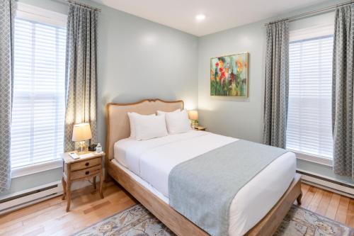 a bedroom with a bed and two windows at The Outlook Inn in Newport