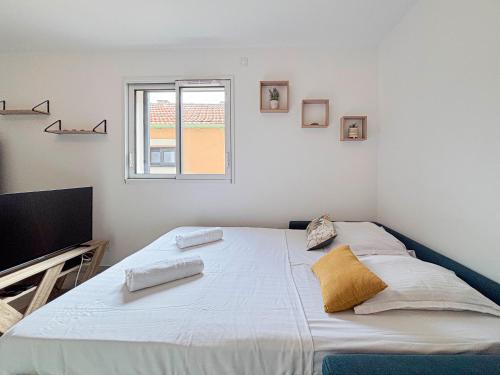 une chambre blanche avec un grand lit et une fenêtre dans l'établissement Confort & Élégance - Wifi, 2 pers, à Nice