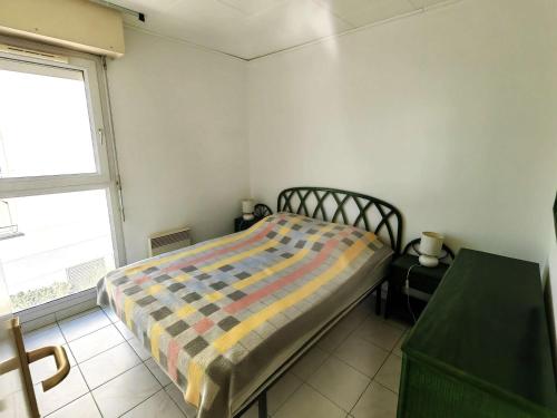 une petite chambre avec un lit et une fenêtre dans l'établissement Agréable T3 avec terrasse et grande piscine, à deux pas de la plage - FR-1-607-101, au Cap d'Agde