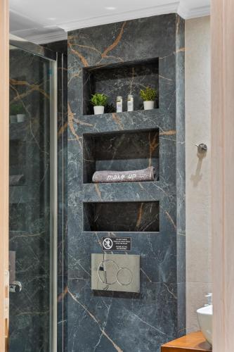 a bathroom with a shower with black marble at Carina Studios Lefkada 2 in Lefkada