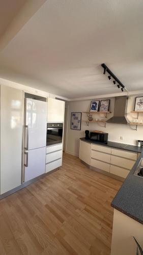 a kitchen with white cabinets and a refrigerator at Løvstræde apartments from 1 to 6 in Copenhagen