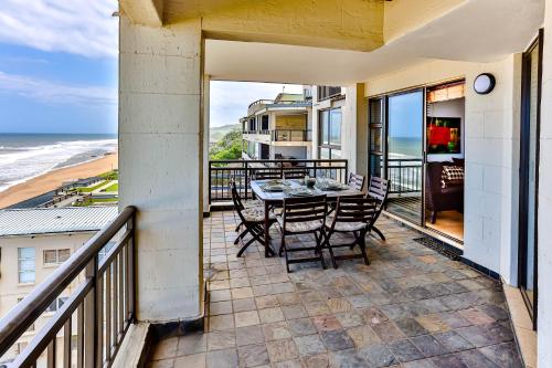 a balcony with a table and chairs and the ocean at Bali Hai 402 in Westbrook