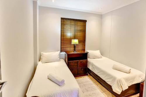 a small room with two beds and a window at Bali Hai 402 in Westbrook