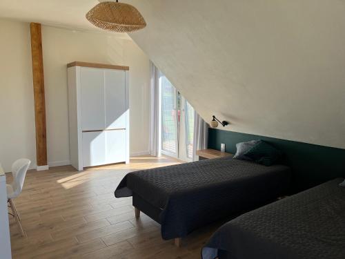 a bedroom with two beds and a large window at Osada Limajno Dom Żurawia in Cerkiewnik