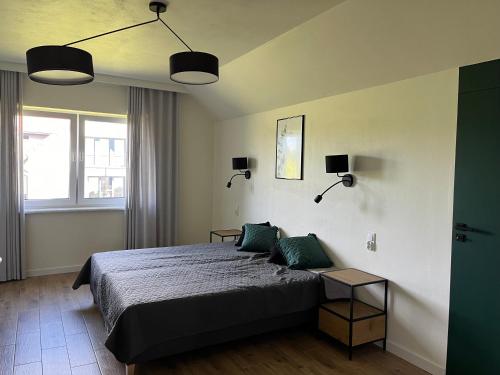 a bedroom with a bed with two green pillows at Osada Limajno Dom Żurawia in Cerkiewnik