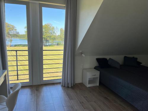 a bedroom with a bed and a large sliding glass door at Osada Limajno Dom Żurawia in Cerkiewnik