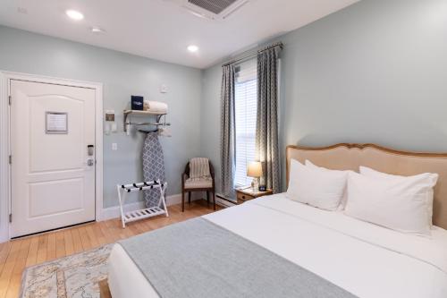 a bedroom with a white bed and a chair at The Outlook Inn in Newport