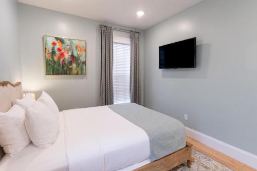 a bedroom with a white bed and a television at The Outlook Inn in Newport